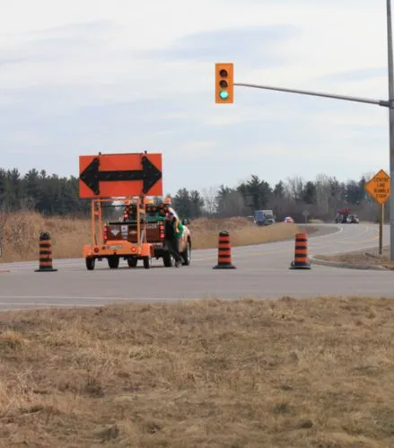 Temporary traffic control setup with arrow board and cones managing lane closure at an intersection safely