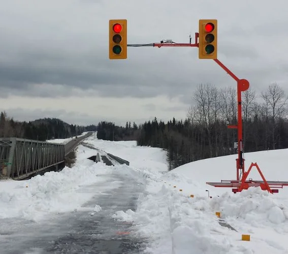 Temporary traffic signal system managing vehicle movement at a snowy construction zone road closure