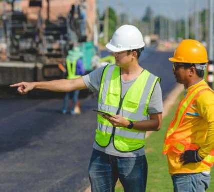 Traffic engineers coordinating road construction activities and reviewing traffic control plans on site