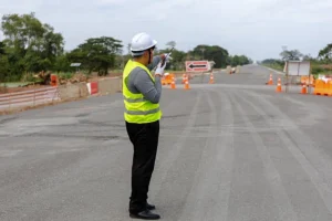 Traffic management plan supervisor directing vehicles at a road construction site using safety cones and signage