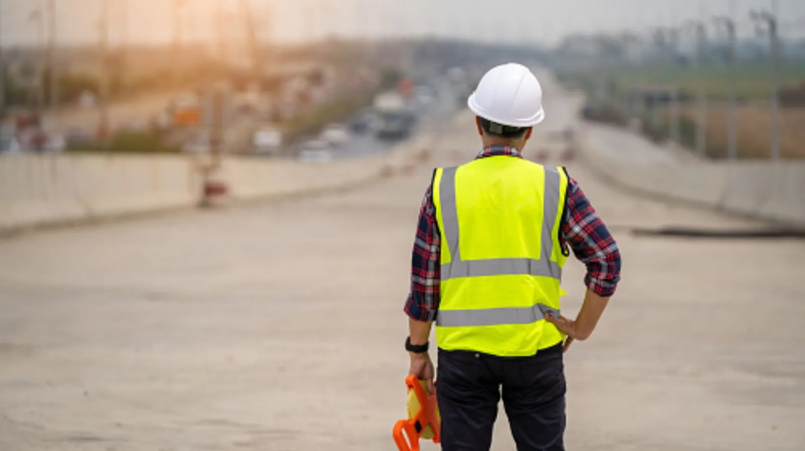 Engineer planning traffic control design timeline with laptop and safety helmet