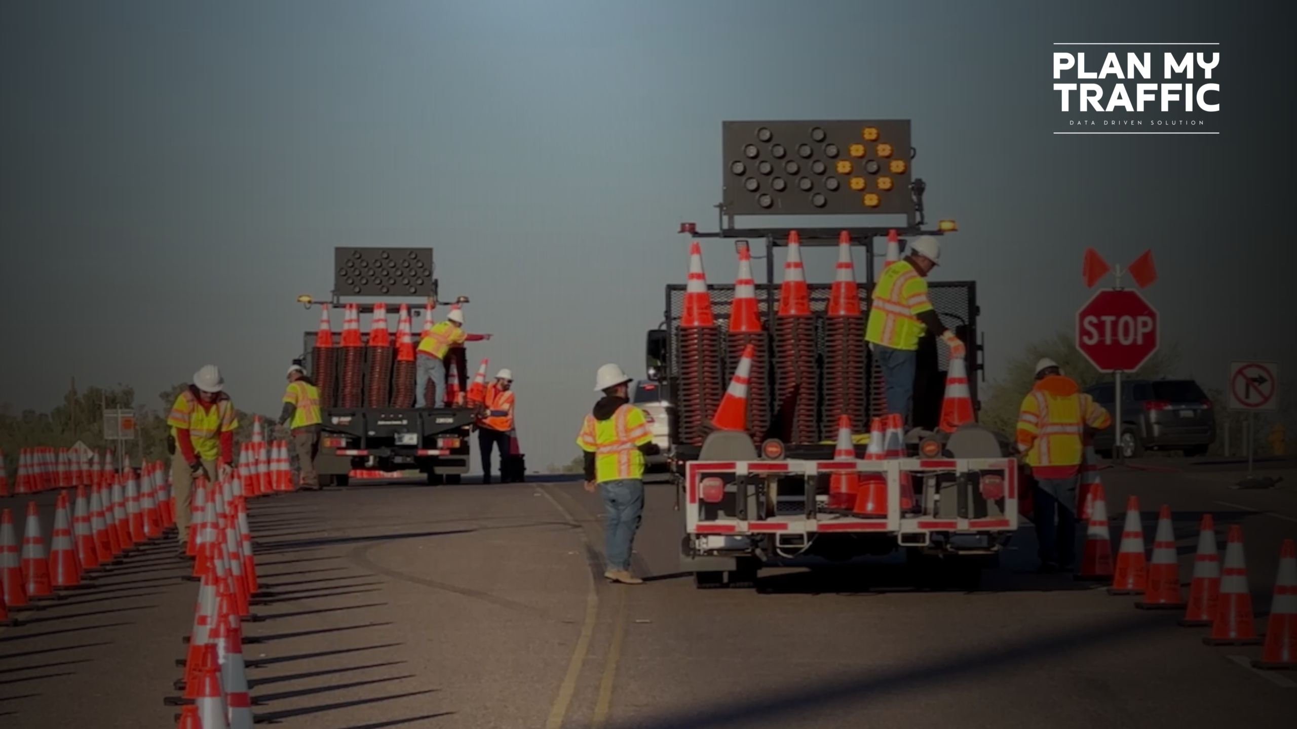 Construction crew setting up cones and signage for construction permit traffic plans in a road work zone.