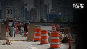 Urban road construction site with cones and workers showing Construction Traffic Control Plan Surrey setup