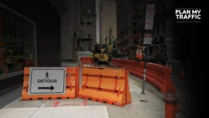 Pedestrian Detour sign and barriers guiding walkway around construction site