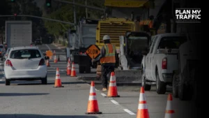 Road construction worker managing traffic with cones and slow sign causing Traffic Control Plan Rejections in BC
