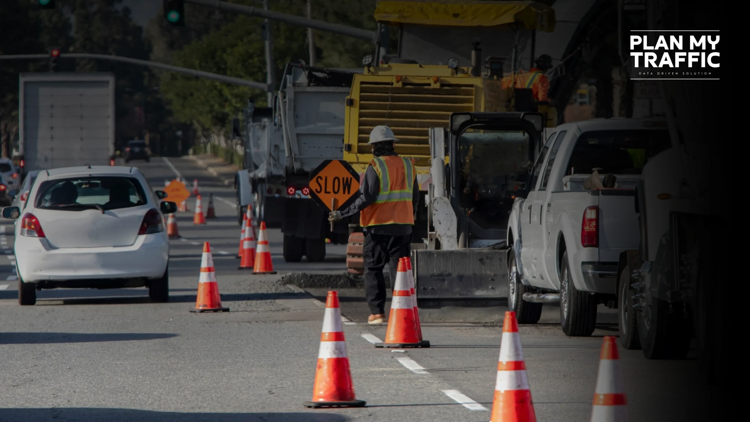Road construction worker managing traffic with cones and slow sign causing Traffic Control Plan Rejections in BC