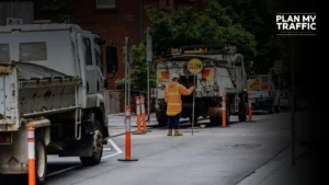 Road worker managing traffic with slow sign under Traffic Management Plan British Columbia