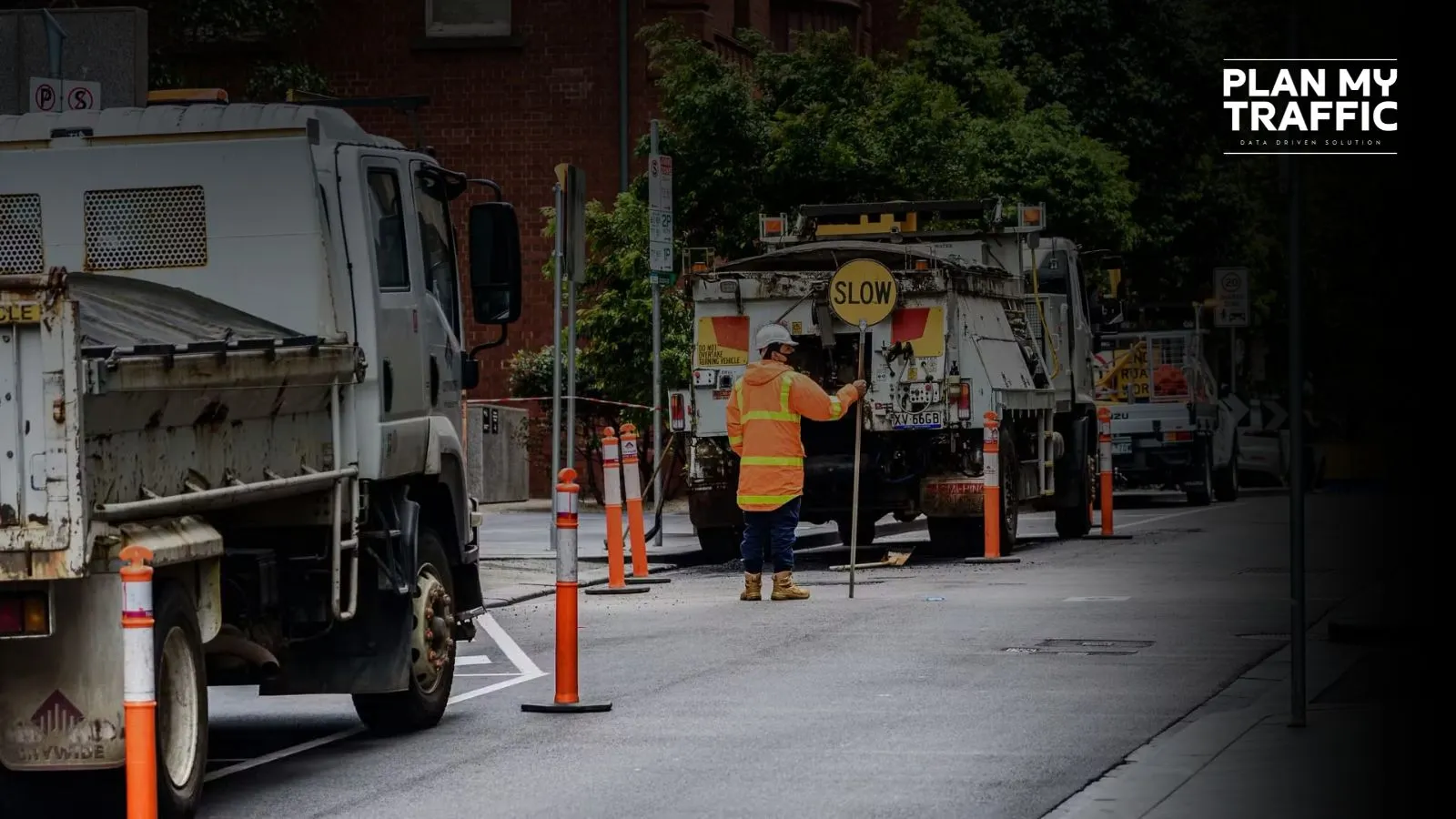 Road worker managing traffic with slow sign under Traffic Management Plan British Columbia