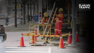 Workers setting up cones and barriers for Work Zone Traffic Control Plan in urban street