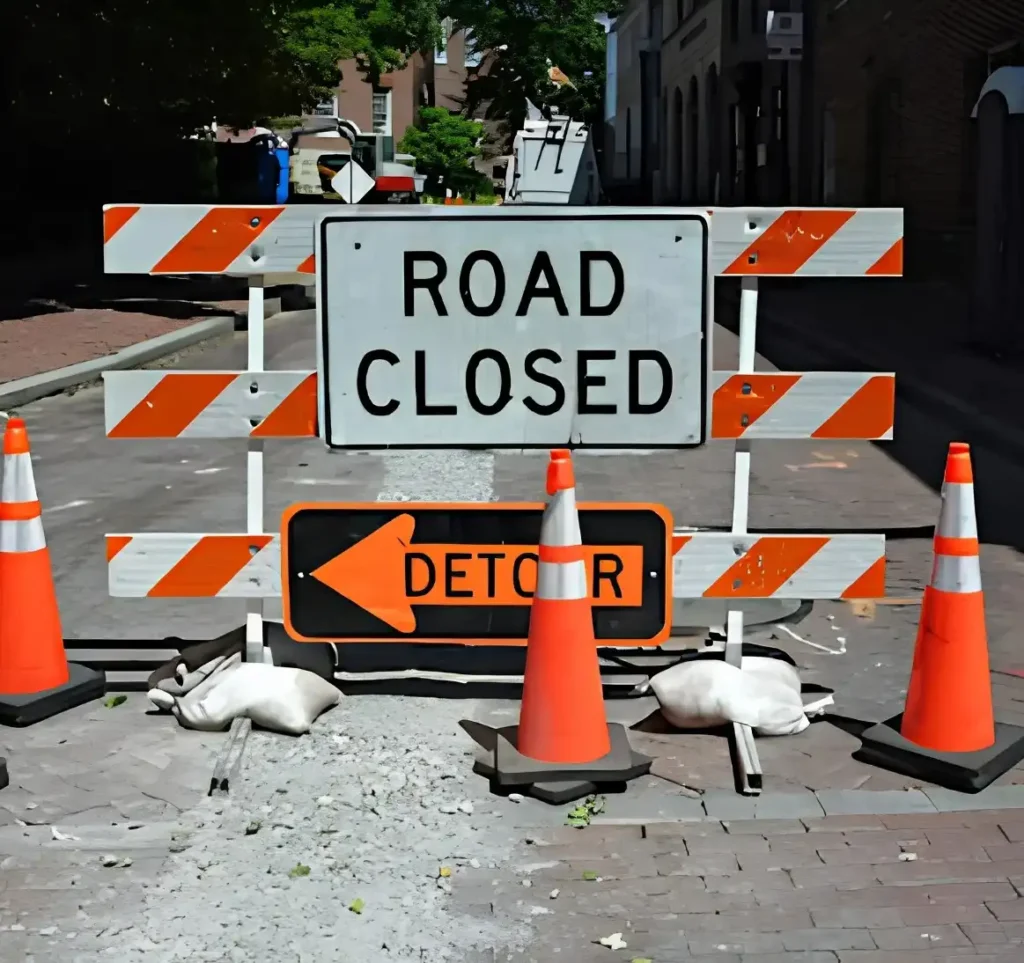 Road closed and detour signs with traffic cones blocking access to a temporary street closure in Canada
