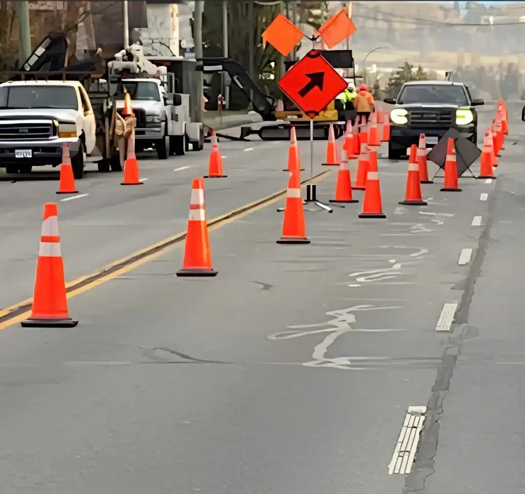 Traffic cones and directional signs guiding vehicles through a road construction lane closure